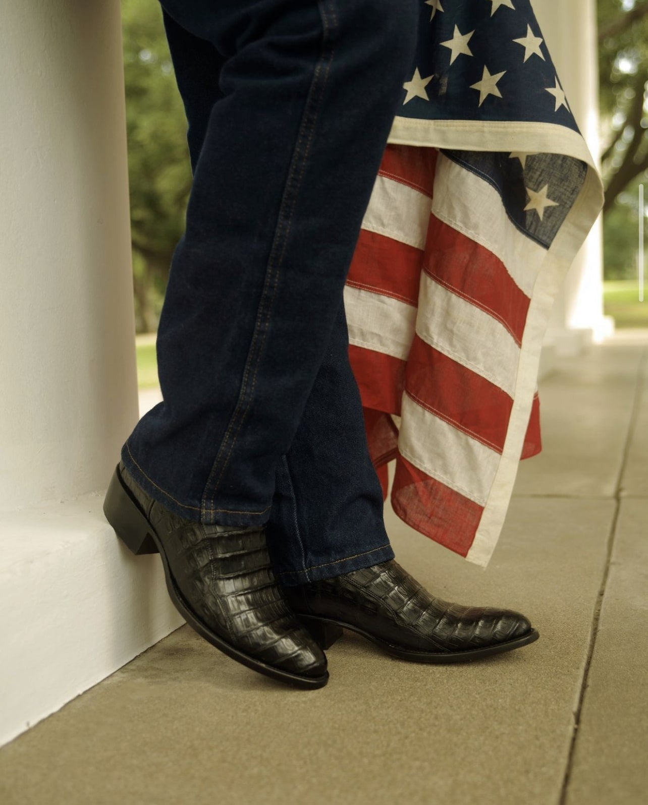 Caiman cowboy boots next to American flag