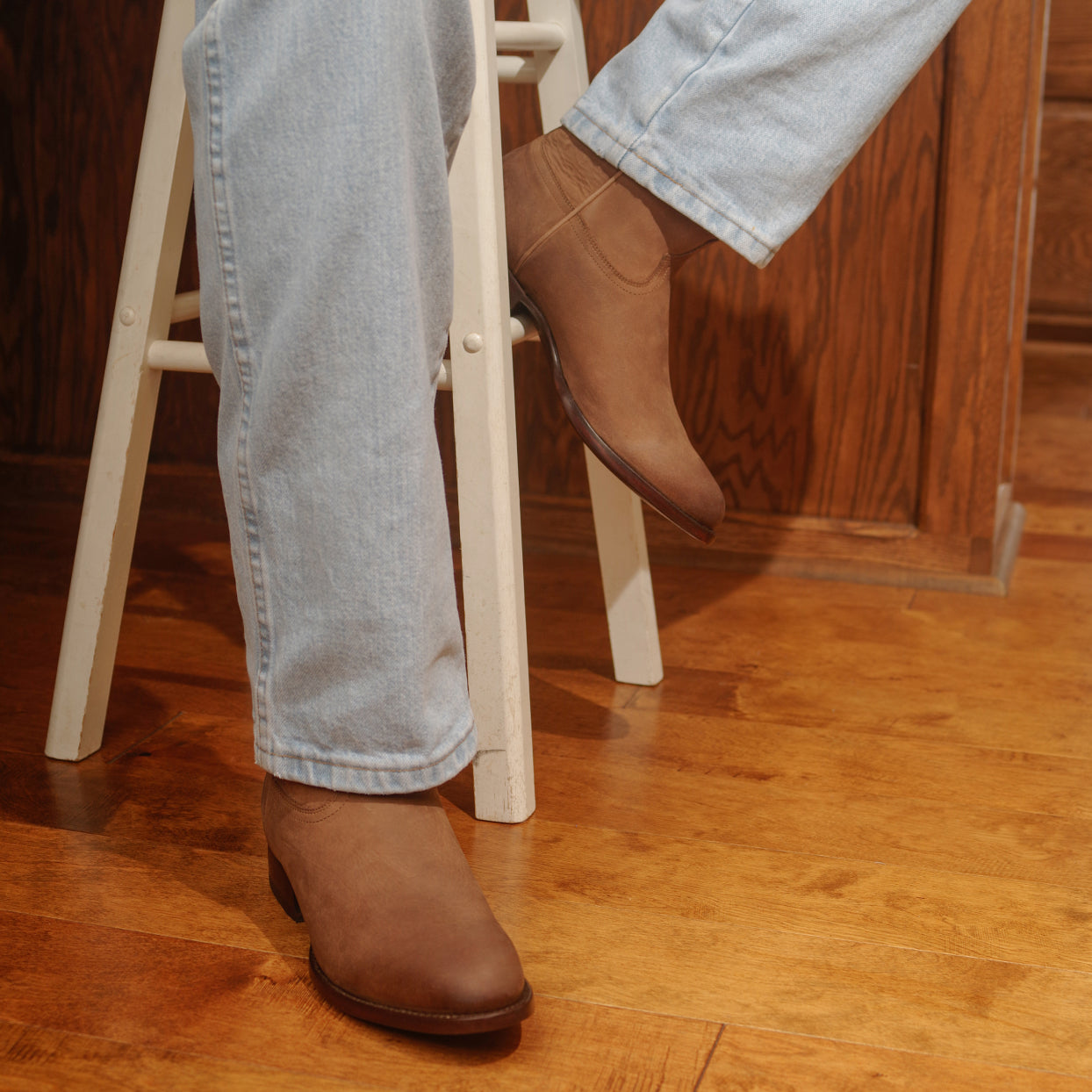 Man leaning on a stool wearing men's RUJO Rock Ranch Calfskin cowboy boots