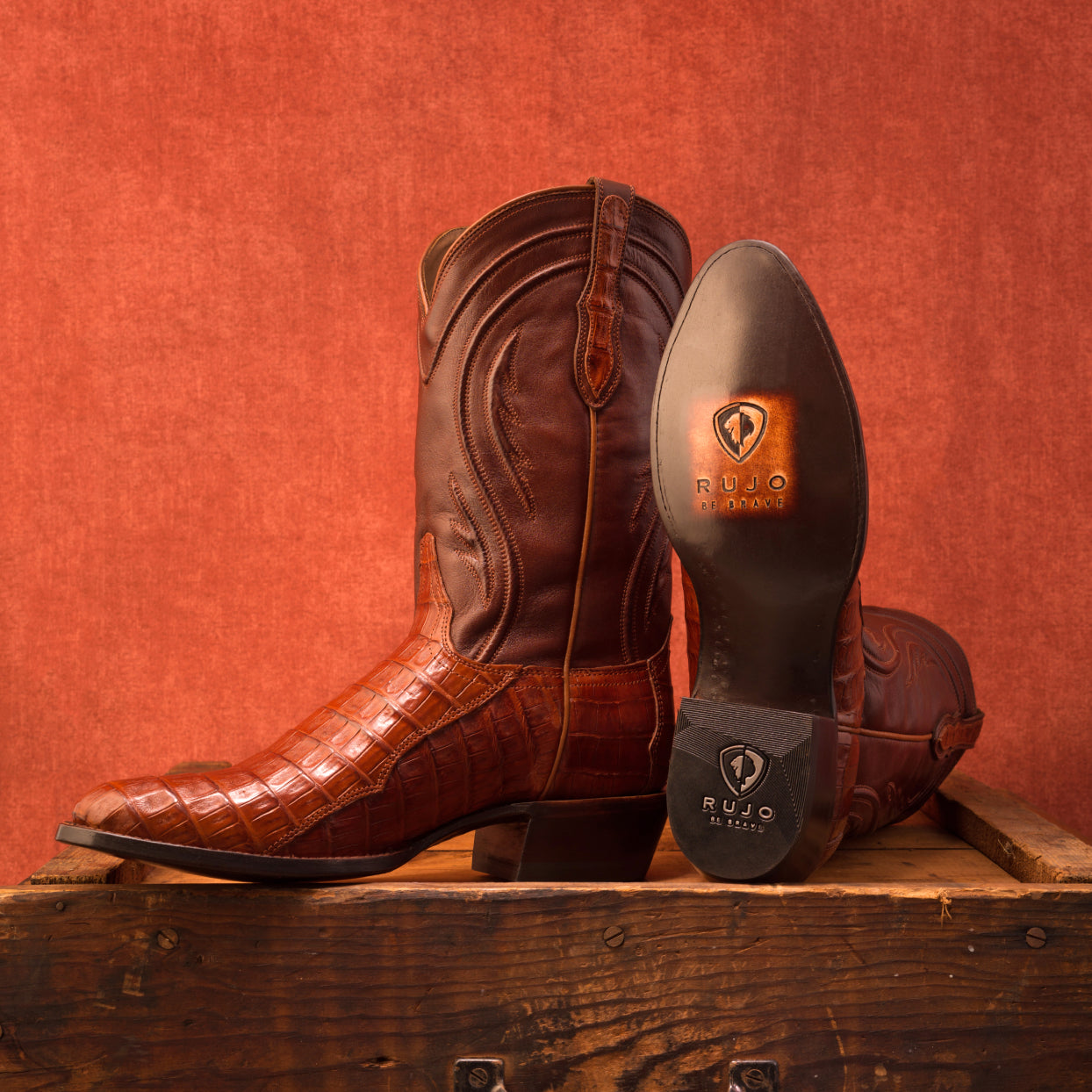 A propped up pair of RUJO caiman cowboy boots ready for a photo shoot