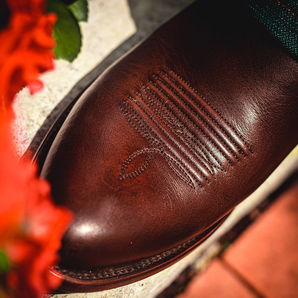 A close-up image of a RUJO Caravan Calfskin cowboy boot and it's toe medallion