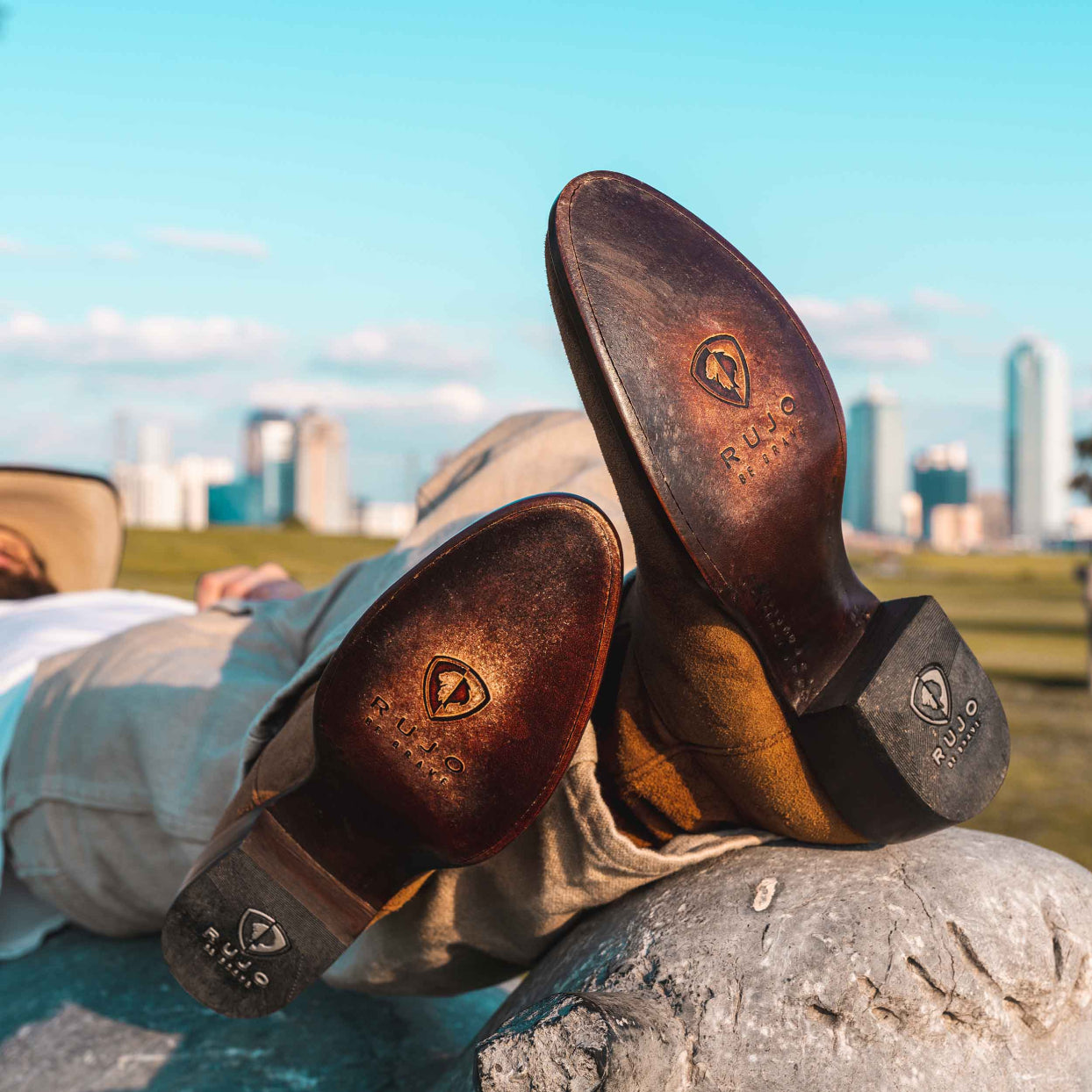 Man sitting cross-legged showing the bottom of his RUJO Sentry Suede cowboy boots