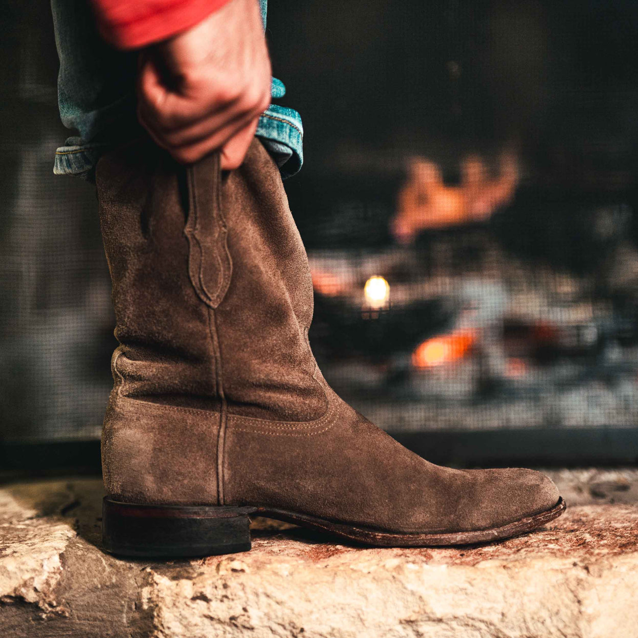 Man using the pull straps on his RUJO Sentry Suede cowboy boots by RUJO