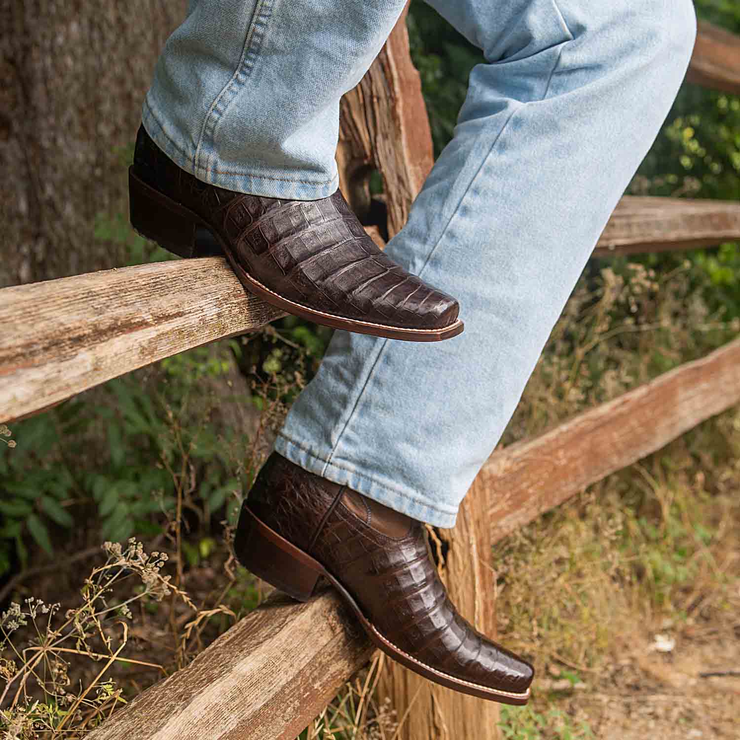 Man sitting on fence wearing brown RUJO cowboy boots